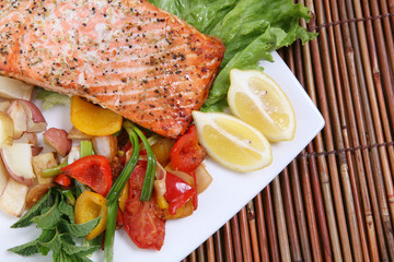 A baked salmon dinner with vegetables and potatoes
