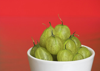 Bowl of Gooseberries on a Red Background
