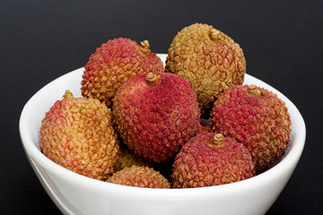 Bowl of Fresh Lychees on a Black Background