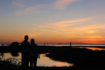 Fototapeta na wymiar Młoda para na plaży o zachodzie słońca
