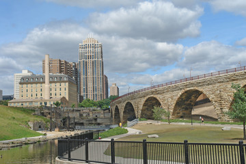 Naklejka premium Stone Arch Bridge curving toward buildings