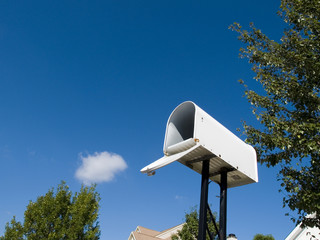A white mailbox against a fresh blue sky.
