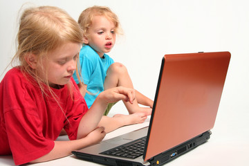 Two little girls playing on laptop 