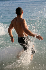 Young man running in the water