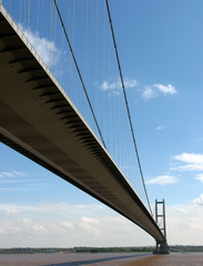 Close-up of suspension bridge aginst cloudy blue sky