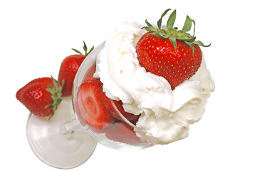Strawberries and whipped cream in glass. Clipping path.