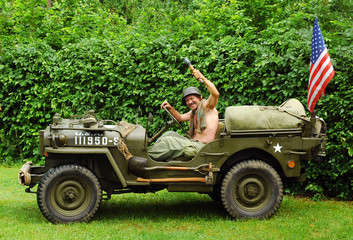 Fototapeta premium Man in military style in old fighting jeep 