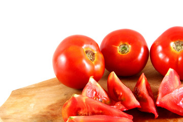 tomatos on a wooden plate cut in slices isolated on white