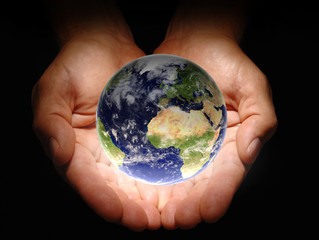 Hands holding the earth on a black background