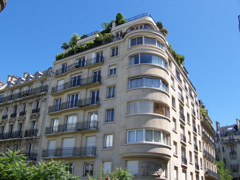 Immeuble au coin arondi sur ciel bleu pur, Paris