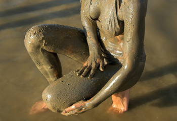 half naked woman add dead sea clay