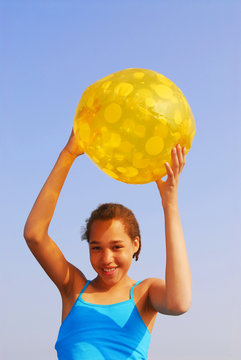 Pretty Young Girl Holding A Yellow Beach Ball Outside