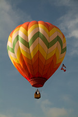 Colorful Hot Air Balloon ascending into bright blue sky