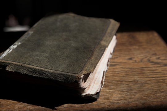Leather covered old bible lying on a wooden table 