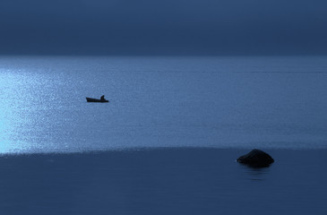 Night, boat with the fisherman in the sea.