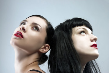 two female portraits with black hair and red lips