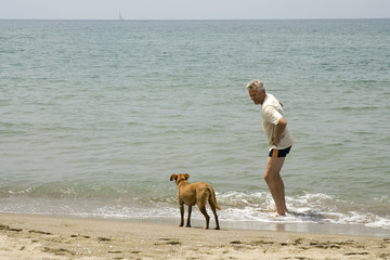 man with his dog at the beach to swim