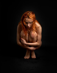 picture of offended naked redhead girl over black