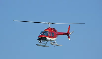 Foto op Canvas A bright red helicopter with a camera.  © Stas