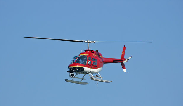 A bright red helicopter with a camera. 