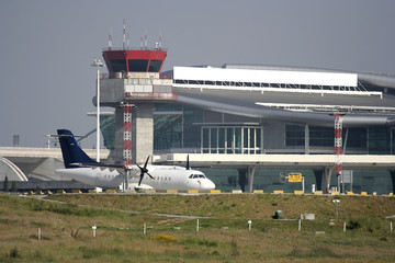 airplane parked at the airport near the tower
