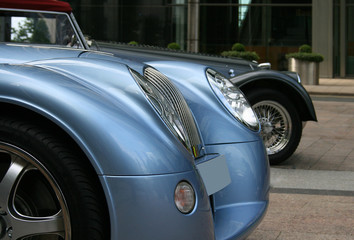 Sports cars in front of building
