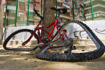 Foto cercana de una bicicleta totalmente rota en el suelo.