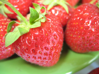 The ripe red strawberry on the plate.