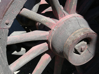 Weathered spokes on the wheel of an old covered wagon