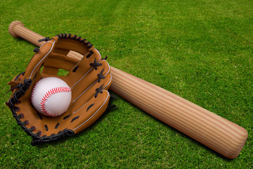 Baseball bat, ball and glove isolated on a field of grass
