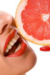 Beautiful young woman eating an orange