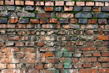Fragment of spotted weathered brick wall with white stucco