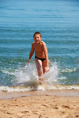 Fototapeta na wymiar A boy running on the beach