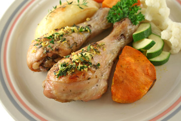 Delicious roasted chicken drumsticks with baked vegetables.