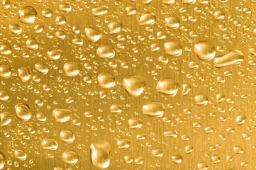 Gold metal with water droplets on.