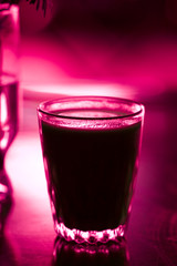 Glass with beverage on red color