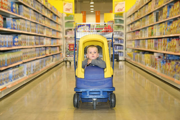 child in the trolley-toycar in the shop
