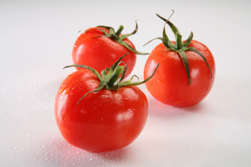 Three tomatoes on neutral background, soft focus on back