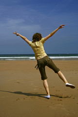 Young girl dancing happy in the beach