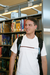 A young student in the library with a backpack