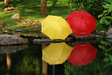 red and yellow color umbrella at the pond side