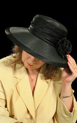 Middle aged woman underneath a black hat.