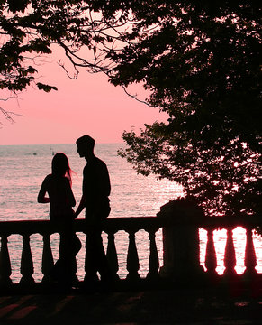 couple on the beach at pink sunset (sunrise)