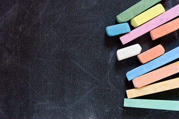 closeup of blackboard with pieces of coloured crayons