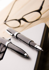 pens, notebook and glasses