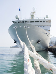 Berthing ropes on a pier with the big ship
