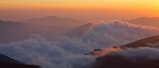 Mountains over the fog in the summer sunrise
