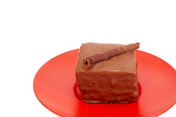 Chocolate mini-cake topped with a swirl on red plate 