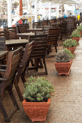 Wooden tables and chairs under umbrellas in restaurant