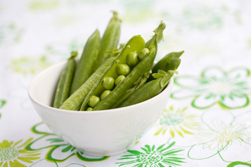 Fresh peas in white bowl, shallow focus